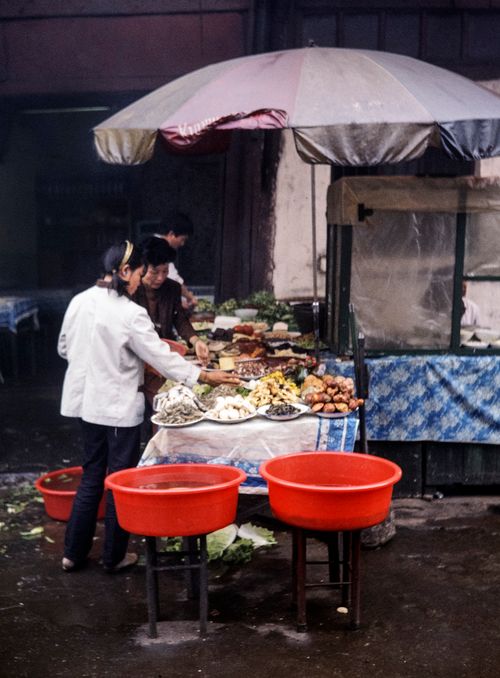 Free Local street food market in China with vendors, fresh produce, and steaming food. Stock Photo