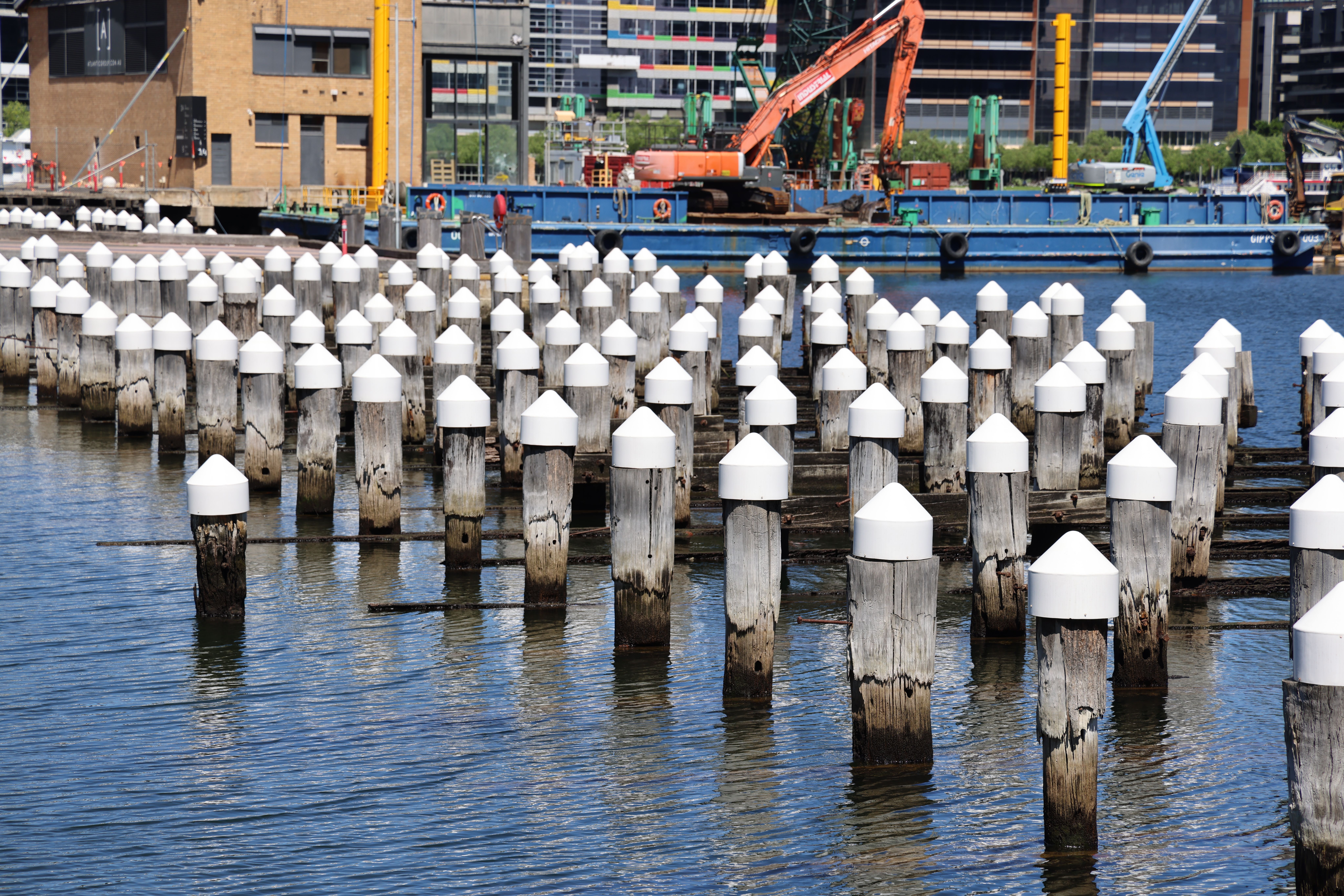 Steel push piers and concrete pilings installed side by side at a Houston foundation repair site showing material differ