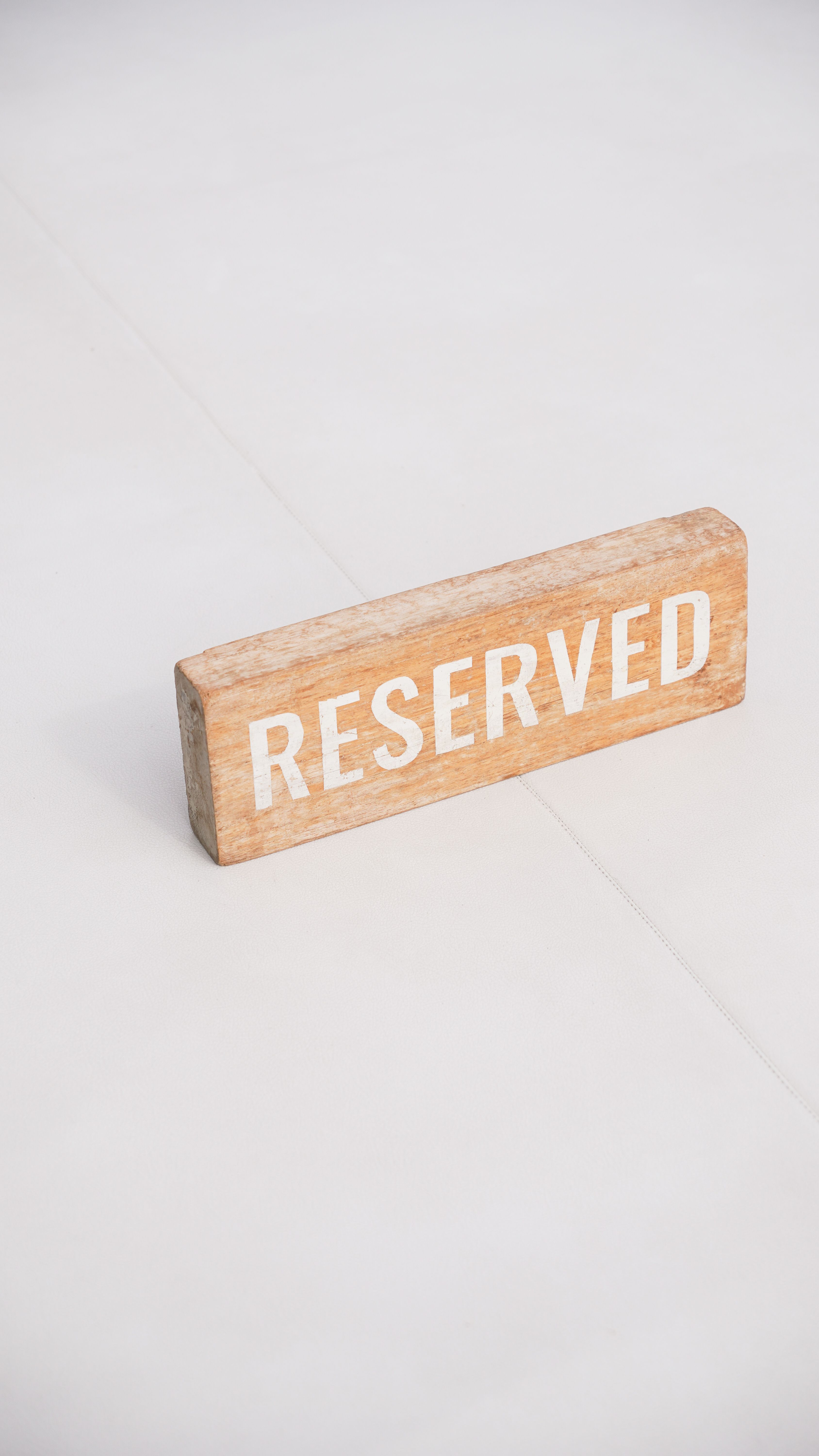 Wooden Reserved Sign on White Surface · Free Stock Photo