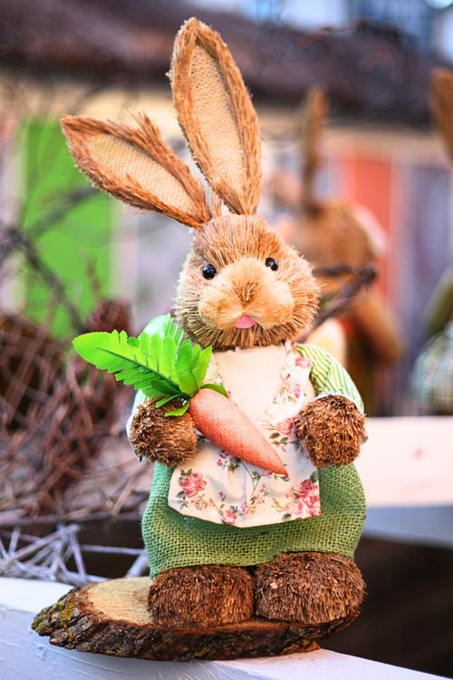 Free Charming Easter bunny decoration holding a carrot, perfect for festive decor. Stock Photo