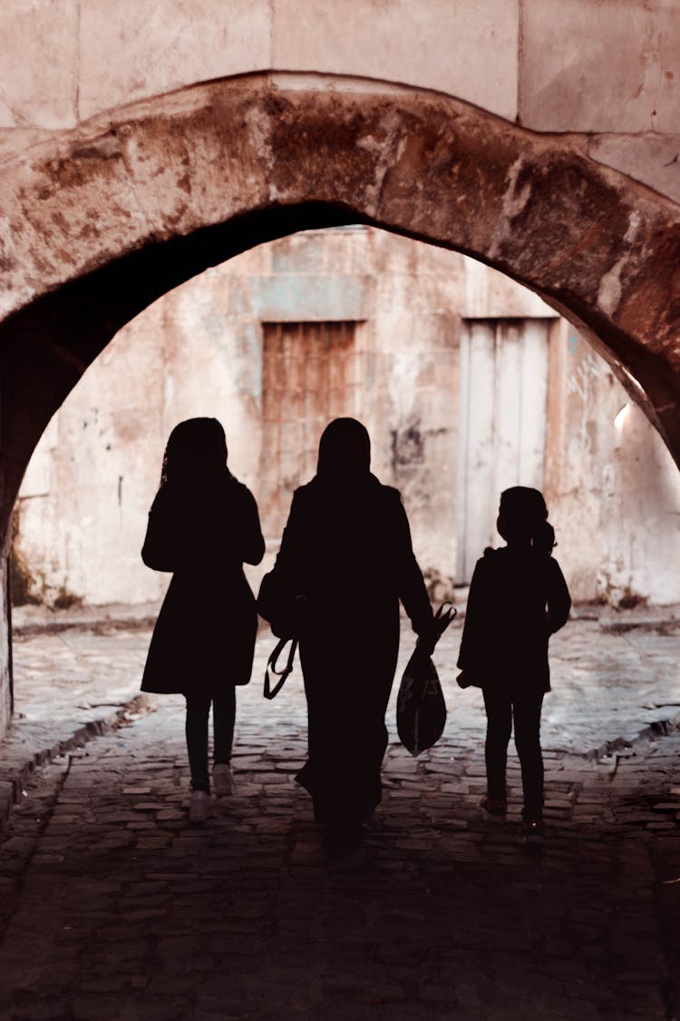 Silhouette Of 3 Women Walking On Tunnel