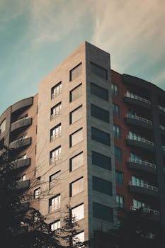 暮色中，一座圆滑的现代摩天大楼展现出独特的建筑设计