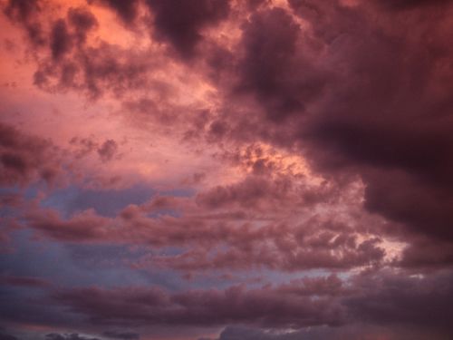 Free A stunning display of dramatic clouds during sunset with a vivid blend of pink and purple hues. Stock Photo