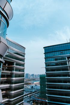 View of modern skyscrapers and skyline in Hangzhou, Zhejiang Province under a clear blue sky.