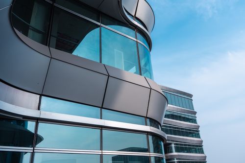 Free Curved glass facade of a modern building against a clear sky in Hangzhou, China. Stock Photo