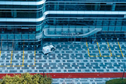 Free Aerial view of Tower 5's sleek glass facade in Hangzhou, China, featuring a geometric parking lot. Stock Photo