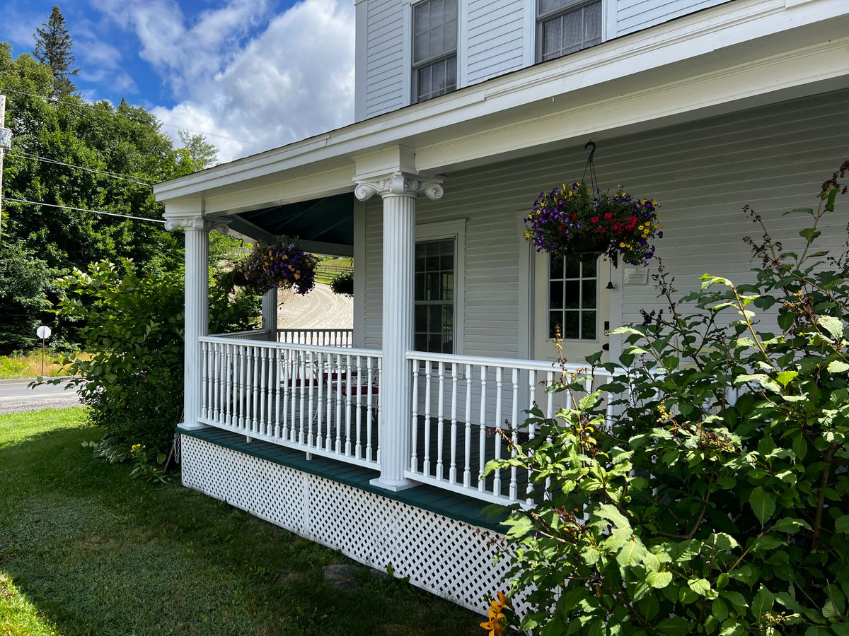 Classic American home porch with hanging baskets and greenery