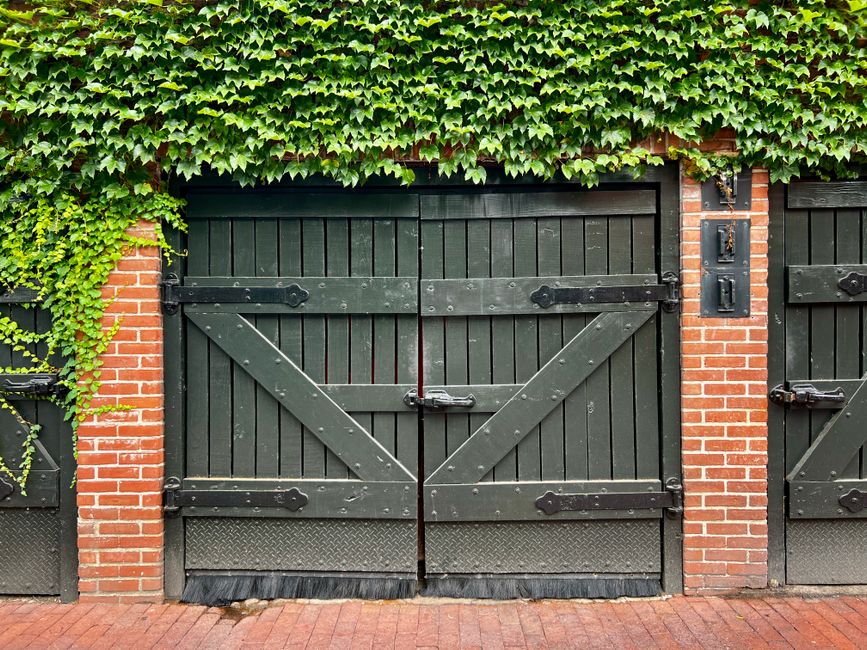 a detached garage in Maryland featuring elegant white carriage house doors with black hardware a detached garage in Maryland featuring elegant white carriage house doors with black hardware