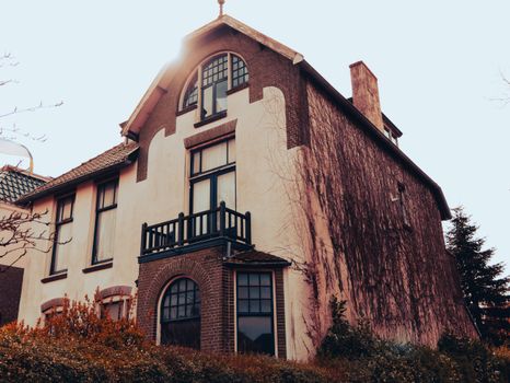 A vintage European house exterior with ivy-covered walls and classic architectural design.
