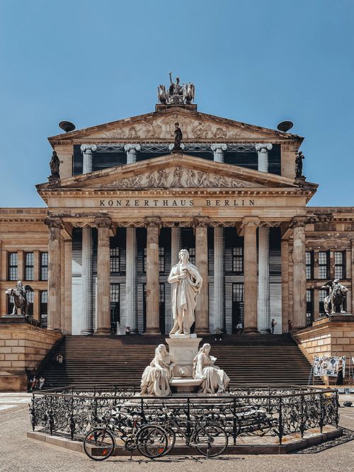 Free Front view of Konzerthaus Berlin with historic statues and bicycles on a sunny day. Stock Photo