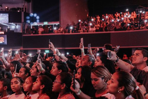 Free Lively audience enjoying a concert, capturing moments with smartphones in a vibrant atmosphere. Stock Photo