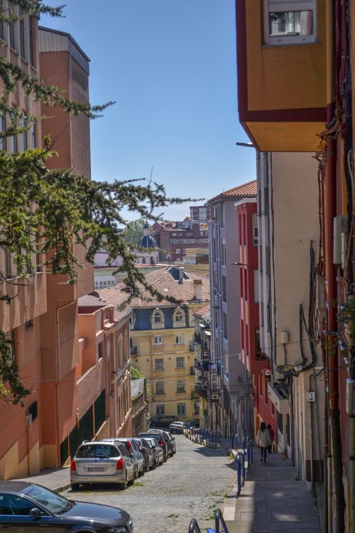 Free A serene view down a colorful, narrow street in Santander, Cantabria, on a sunny day. Stock Photo