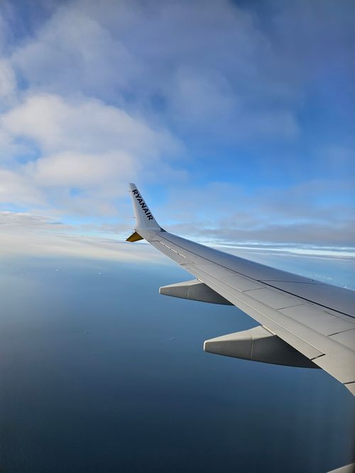 Free Stunning view of the ocean and sky from an airplane window, capturing wing and horizon. Stock Photo