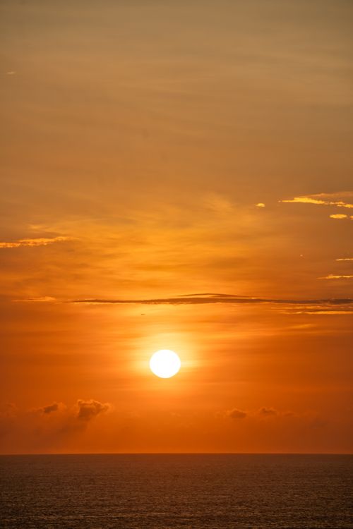 Free A breathtaking sunset over the ocean in Bali, Indonesia, with vibrant orange hues enveloping the sky. Stock Photo