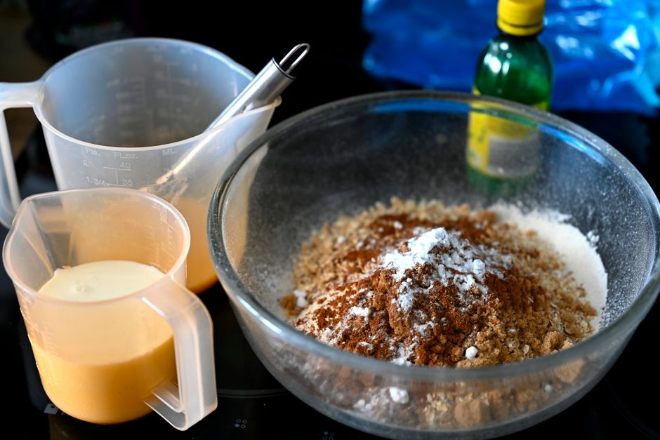 A collection of hair dye removal supplies including baking soda, clarifying shampoo, and a mixing bowl on a bathroom counter.