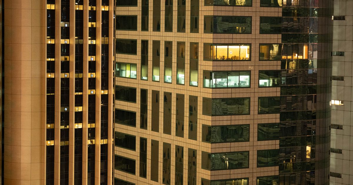 Financial district skyscrapers at night where cross currency swaps are arranged