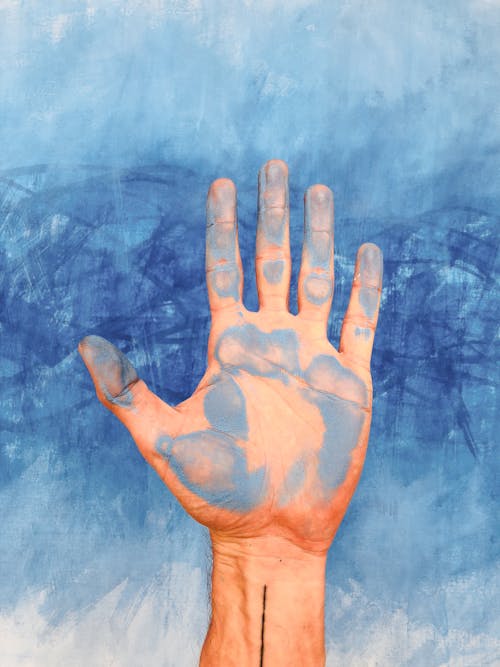 Persons Left Hand on Blue Textile