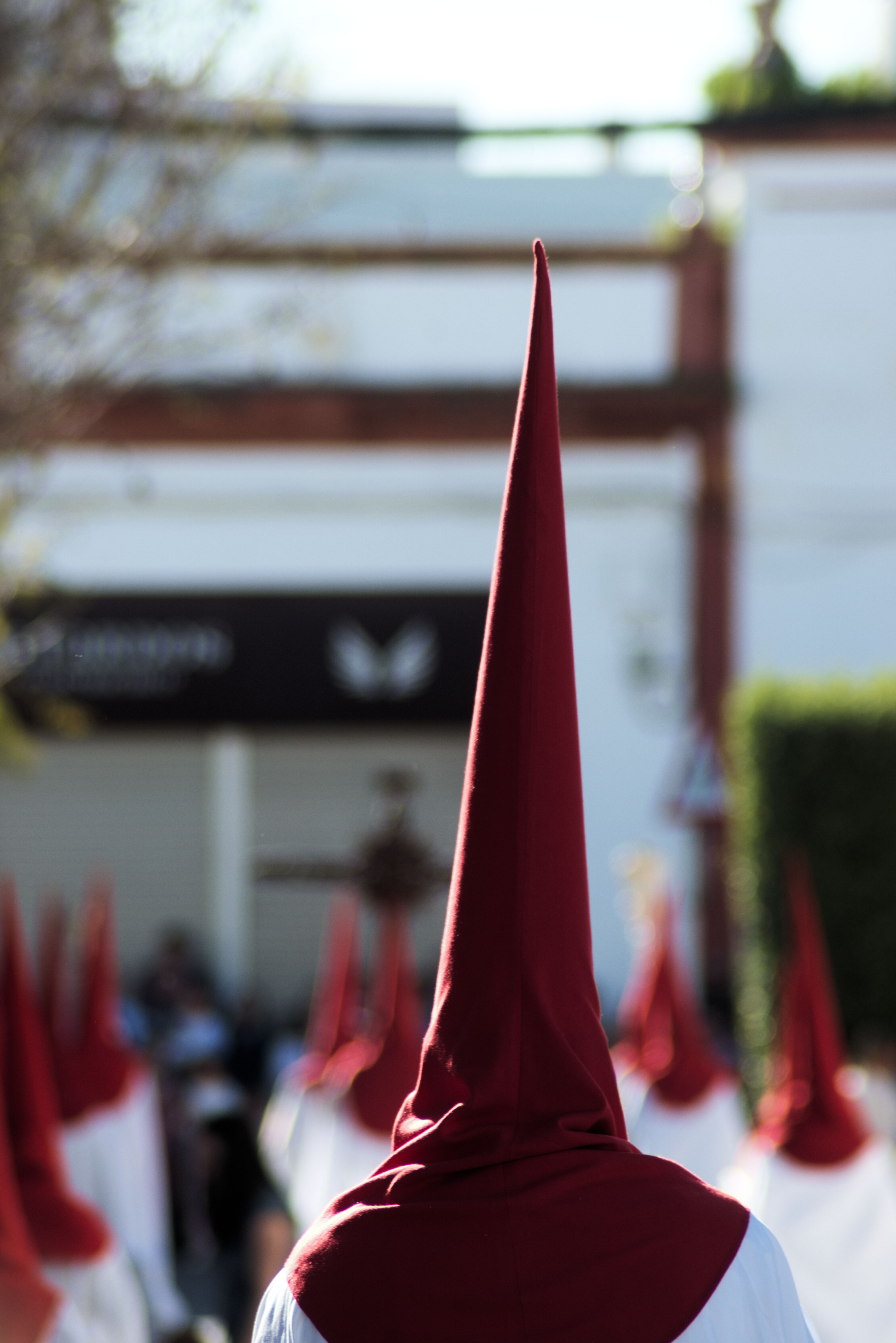 A traditional religious procession featuring hooded penitents in Seville, Spain.