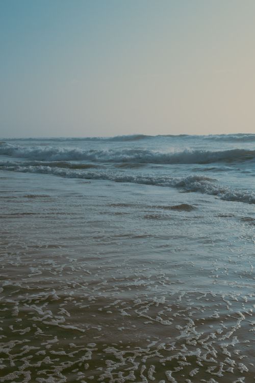 Free Serene beach at dusk with gentle waves in France, perfect for a calming escape. Stock Photo