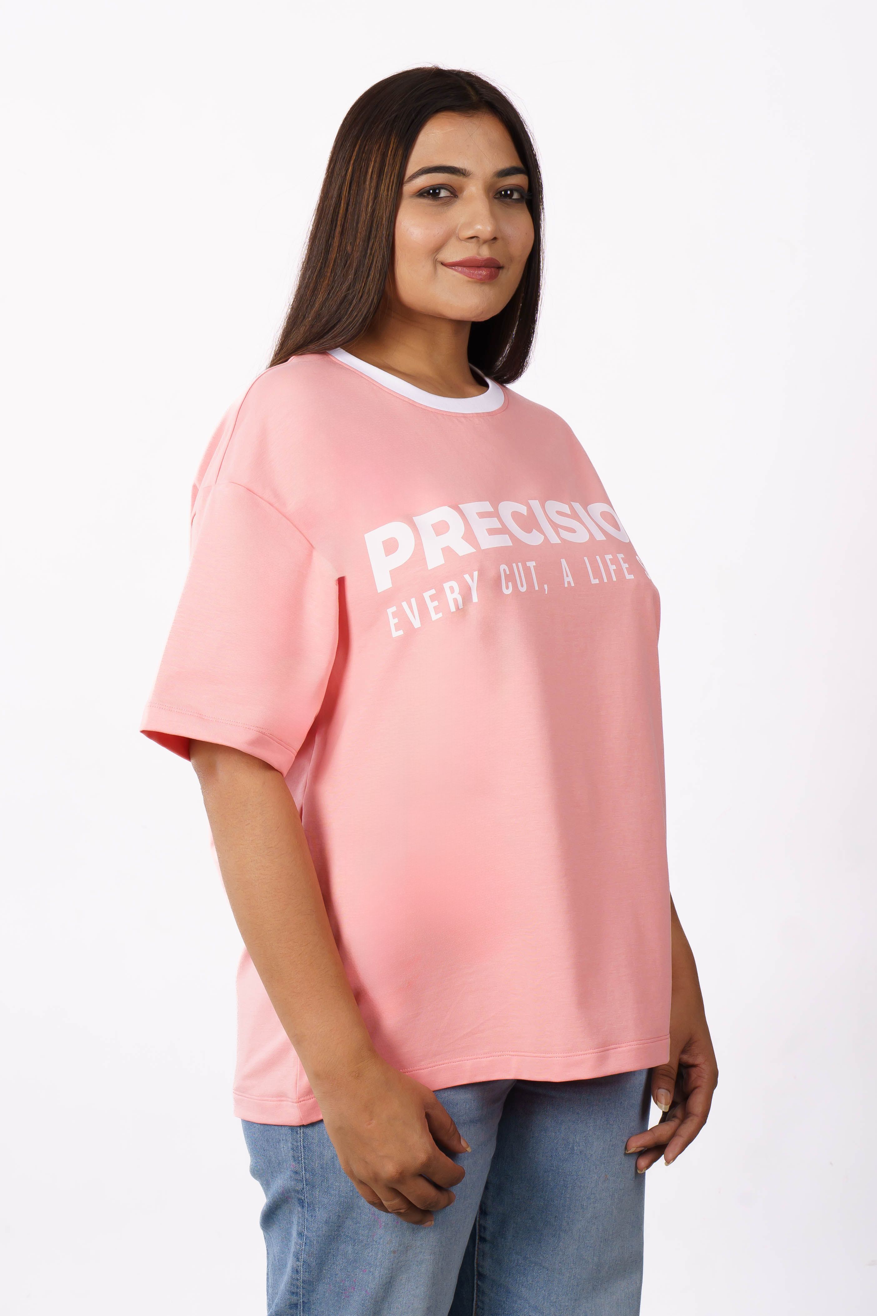 Female model in pink oversized t-shirt with print, isolated on white background.