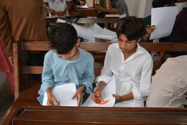 Children drawing together at a church activity table