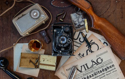 черно серебряный антикварный фотоаппарат на коричневом деревянном столе