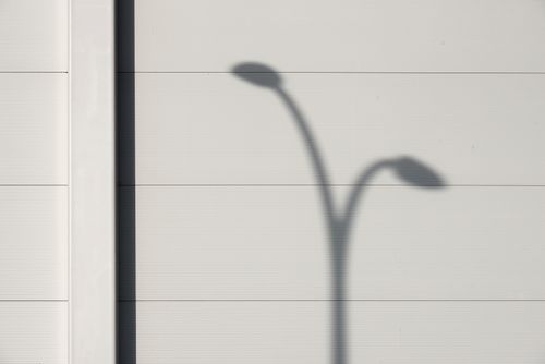 Free Minimalistic shadow of a streetlamp on a textured wall, creating an abstract visual. Stock Photo