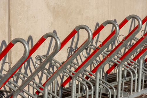 Free Empty bicycle rack with red and silver metal bars creating a geometric pattern in outdoor setting. Stock Photo