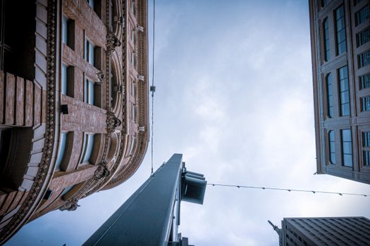 Low-angle view of buildings against a cloudy sky, featuring classic and modern architecture.