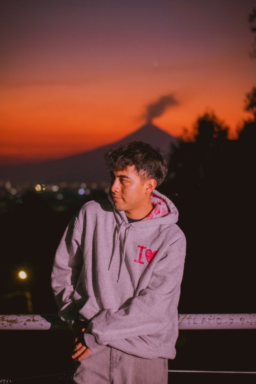 Free A man in a hoodie gazes at Mount Fuji during sunset, creating a serene mood. Stock Photo