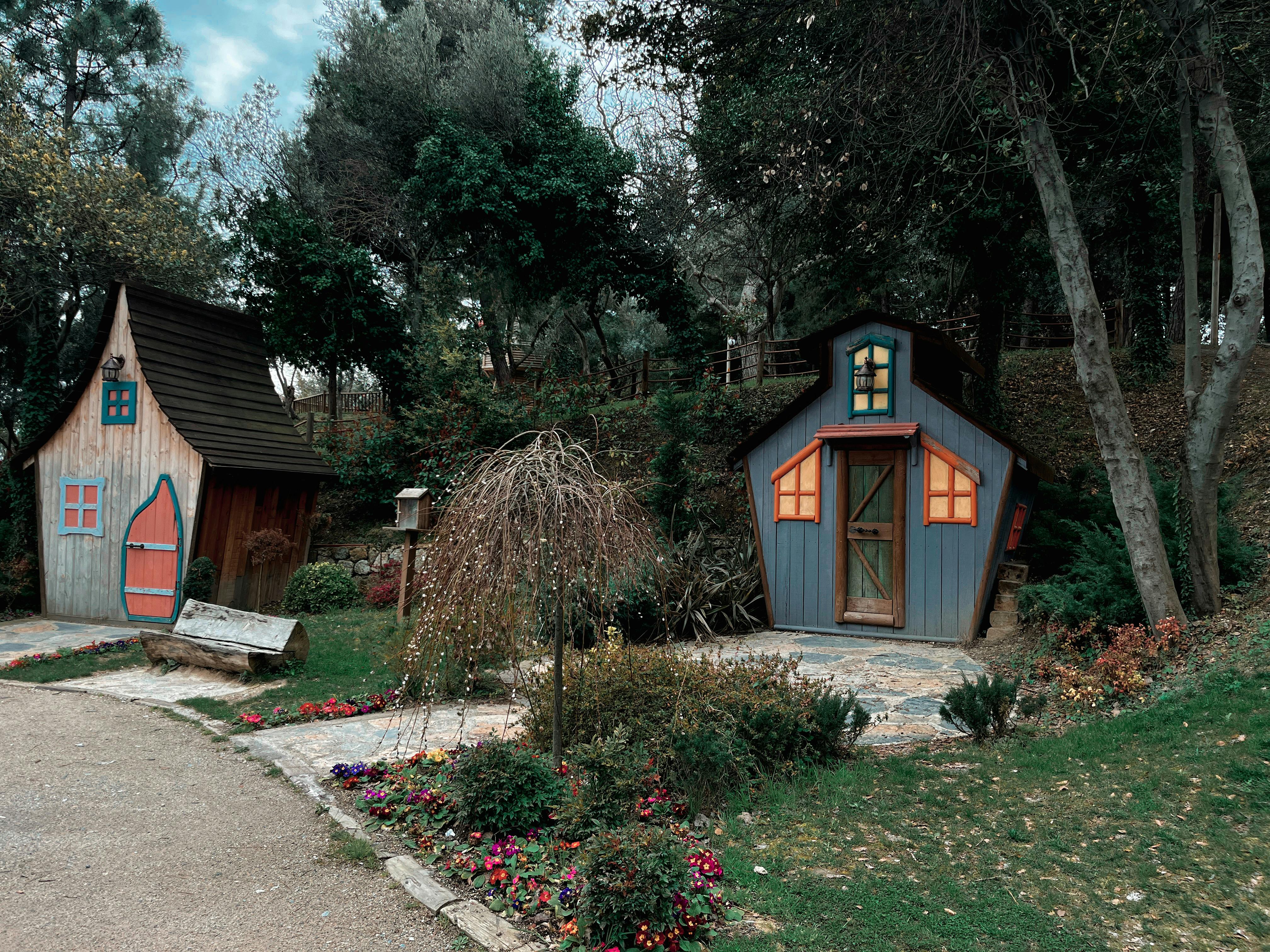 Two whimsical wooden houses nestled in a lush forest, creating a charming fairytale atmosphere.
