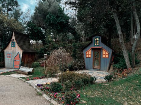 Two whimsical wooden houses nestled in a lush forest, creating a charming fairytale atmosphere.