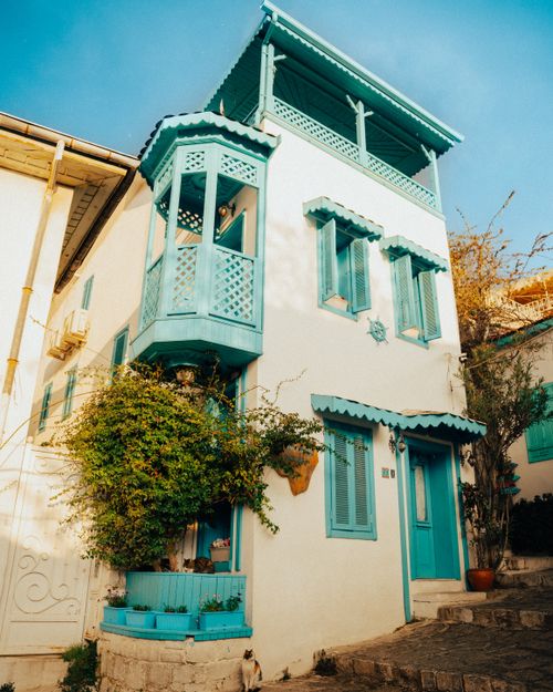 Free Elegant blue and white house in Marmaris, featuring intricate woodwork and lush greenery. Stock Photo