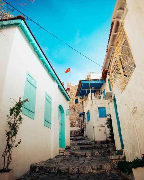 Free Picturesque stone-paved street in Marmaris, Türkiye, flanked by whitewashed houses under a vibrant blue sky. Stock Photo