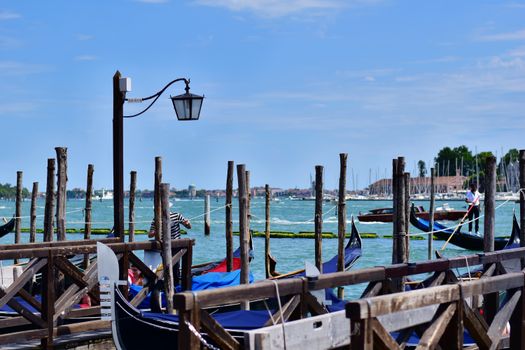 Gondolas docked along the picturesque Venetian seafront, showcasing a lively and iconic Italian scene.