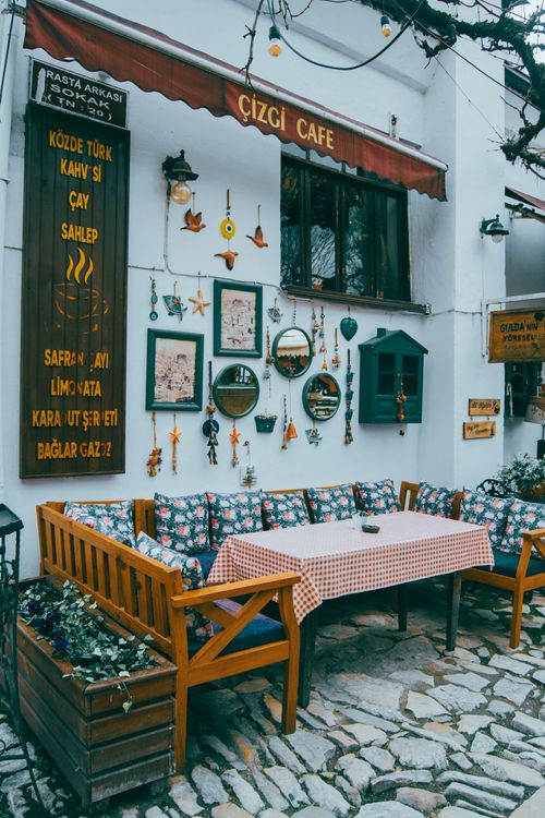 Free Cozy outdoor cafe with rustic decor on a cobblestone street, inviting and picturesque setting. Stock Photo