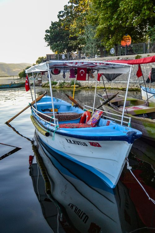 Free A colorful Turkish boat docked by the water, showcasing flags and vibrant decor. Stock Photo
