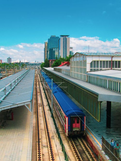 Free Train arriving at station against urban skyline, vibrant and contemporary. Stock Photo