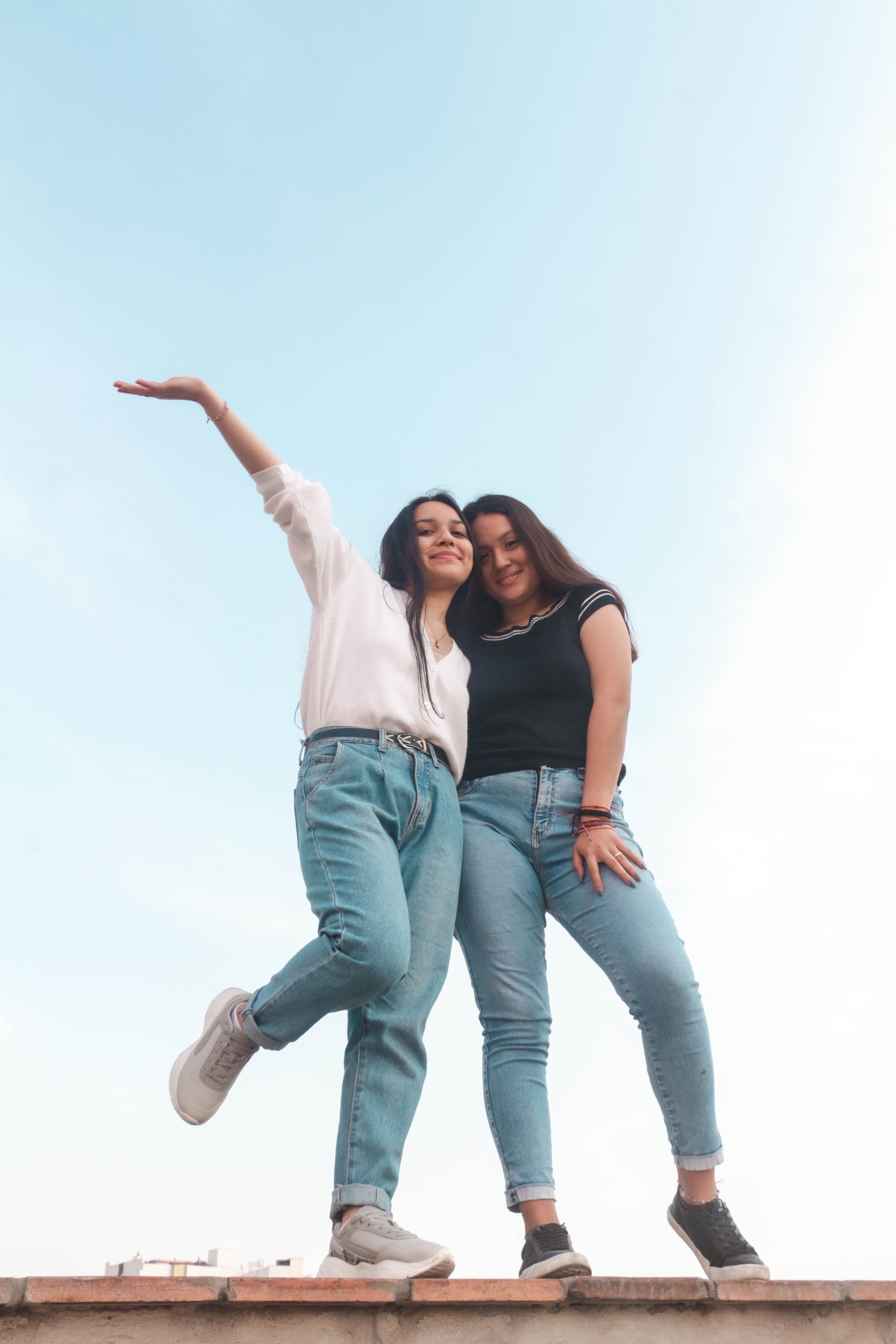 Two young women enjoying a fun moment outdoors in Lima, Peru, under a clear sky.