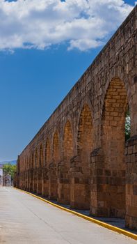 Beautiful stone aqueduct in Morelia, Michoacán, captured under a vibrant blue sky.