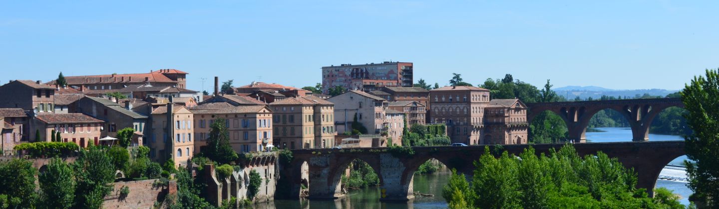 Vue charmante de la vieille ville d'Albi avec un pont de pierre se reflétant dans la rivière.