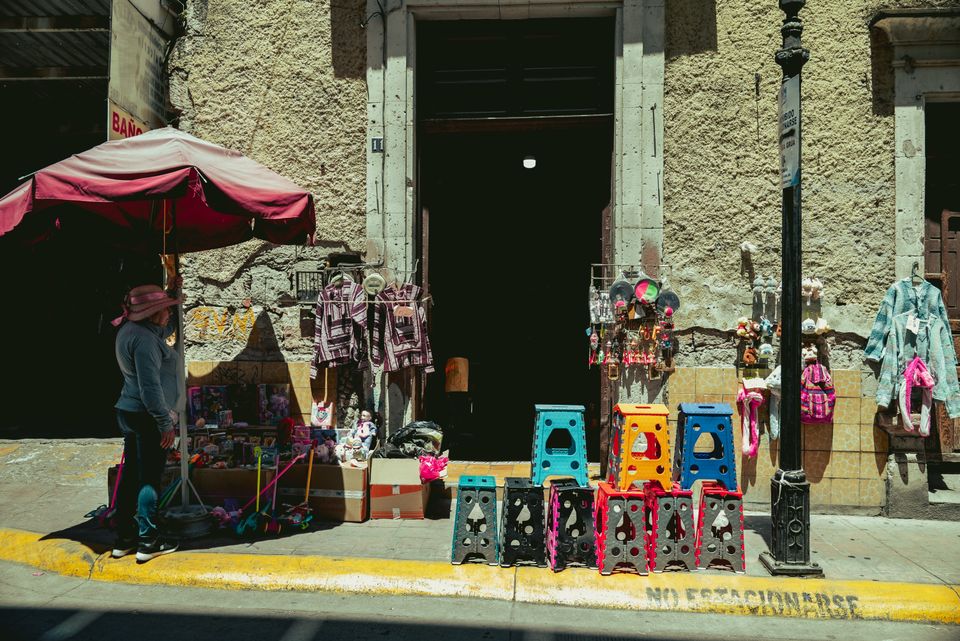 Vendedora independiente mostrando productos en un mercado local
