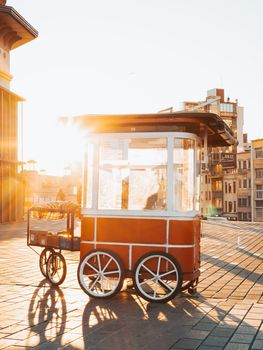 Charming street vendor cart illuminated by the warm glow of the sunset in a cityscape setting.