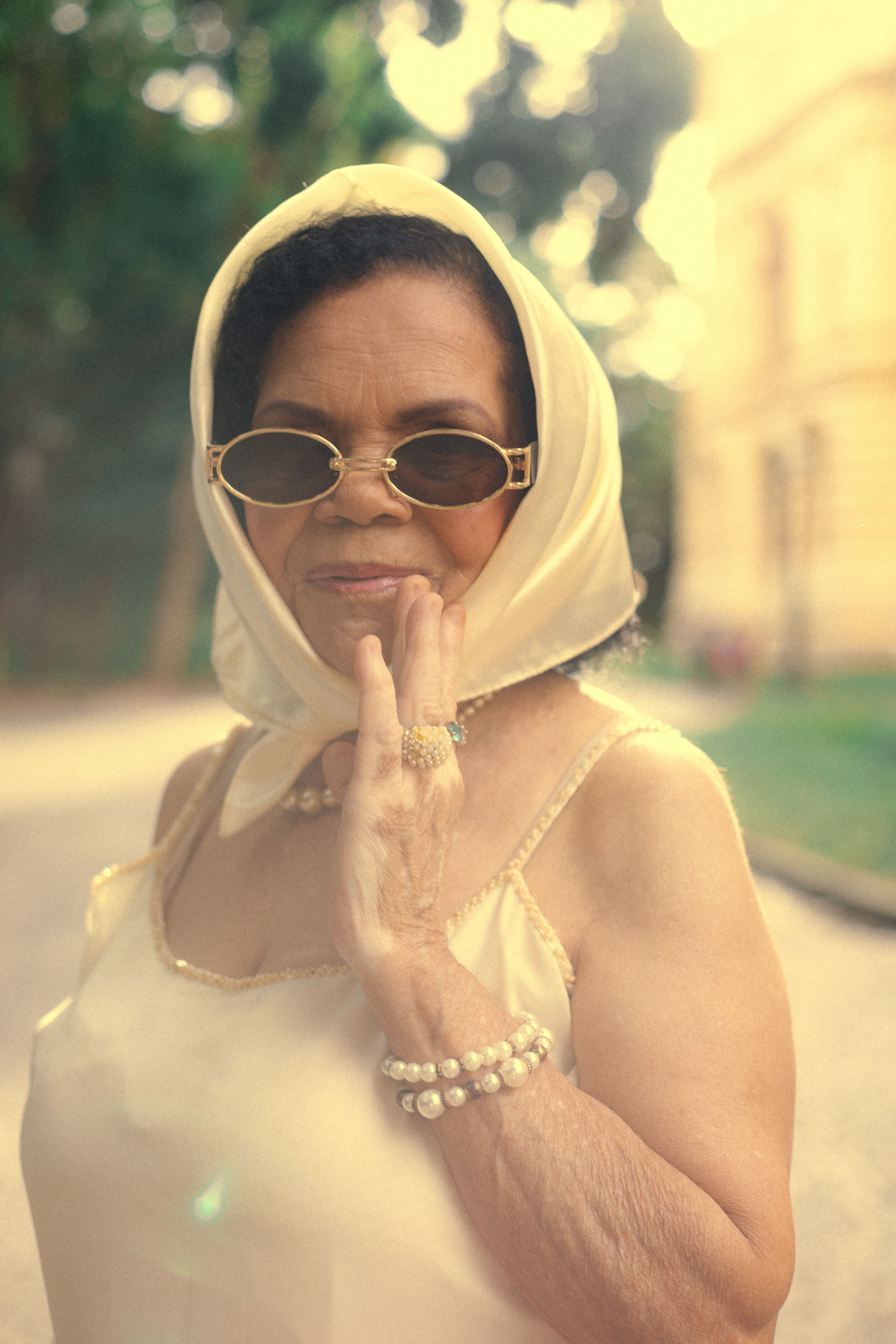 Stylish senior woman with sunglasses and headscarf posing outdoors in São Paulo.