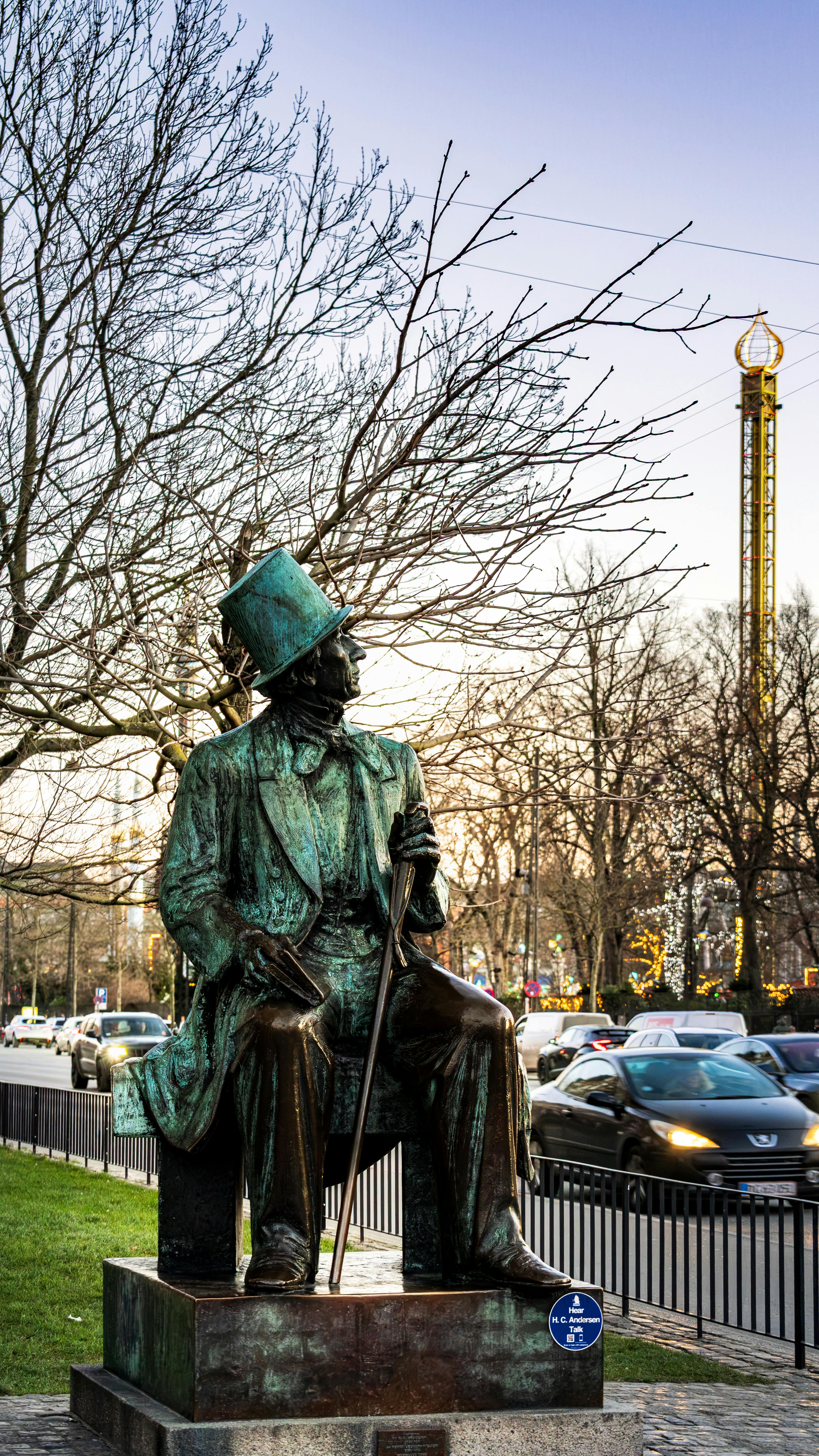 Bronze statue of Hans Christian Andersen at twilight in Copenhagen, Denmark.