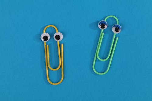 Free Yellow Paper Clip on Blue Background Stock Photo