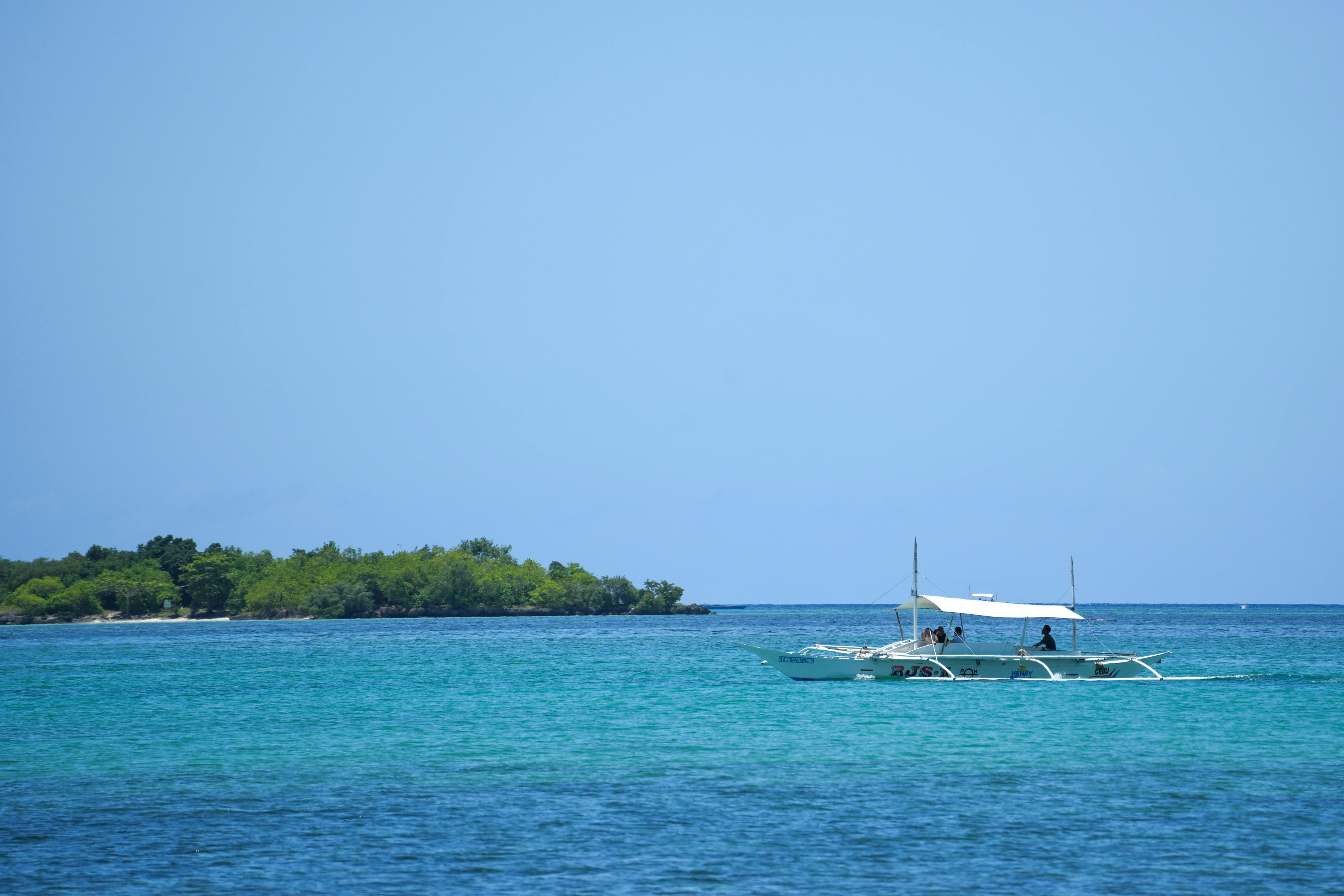 Scenic view of a traditional boat sailing near lush green islands in Central Visayas, Philippines. (Photo: Kaiser Concha)