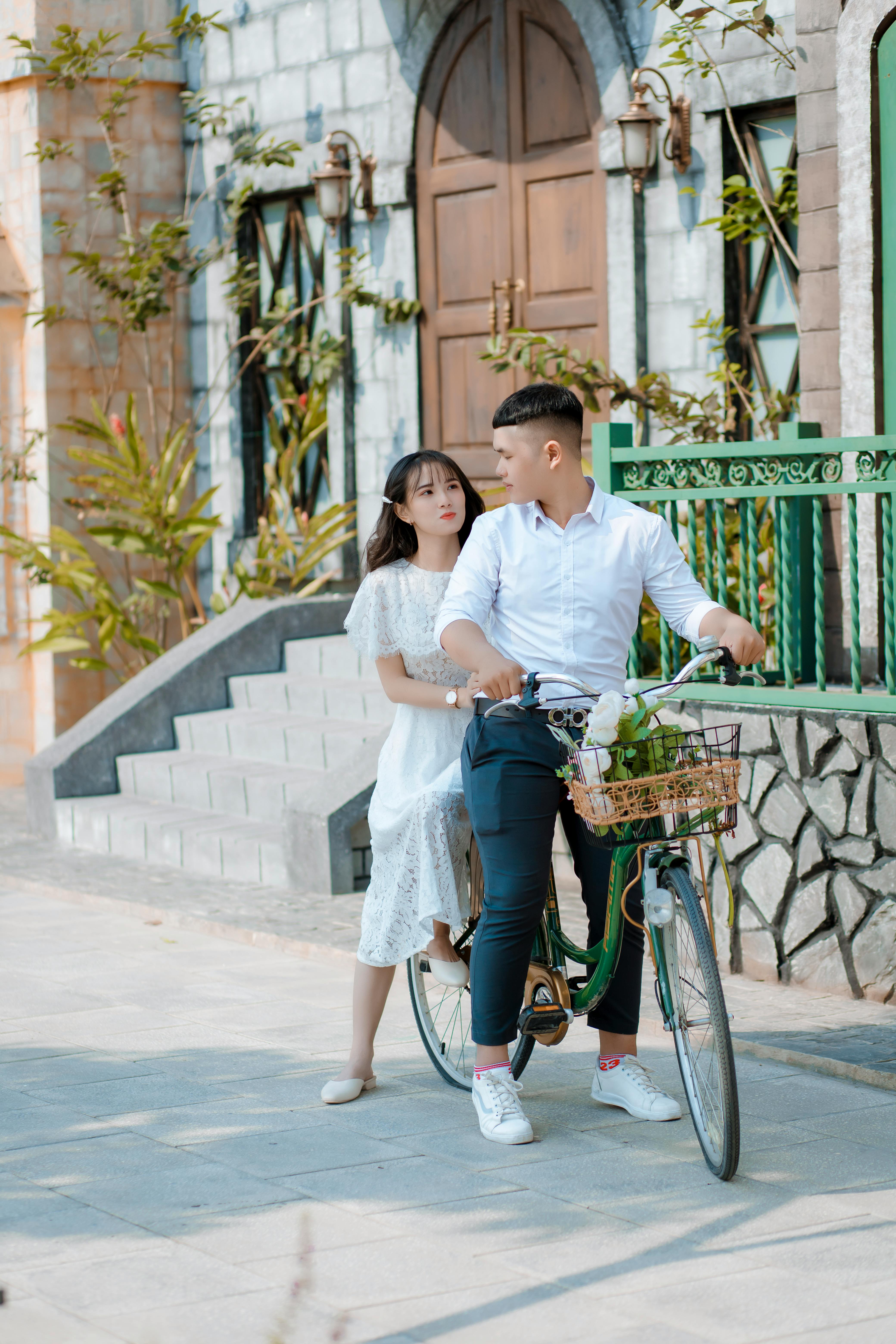 man and woman riding green bicycle