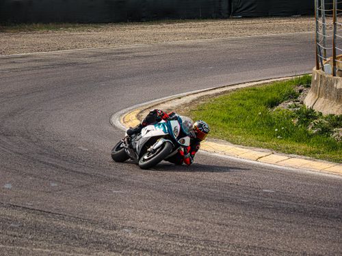Free Motorcyclist leaning into sharp curve on asphalt track during daytime race. Stock Photo