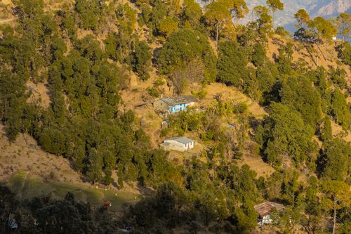 Free Picturesque view of a mountain village nestled amidst dense forests in Uttarakhand, India. Stock Photo